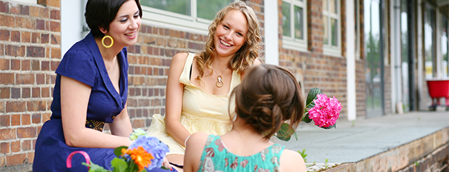 Drei hübsche Frauen unterhalten sich angeregt und lachen miteinander