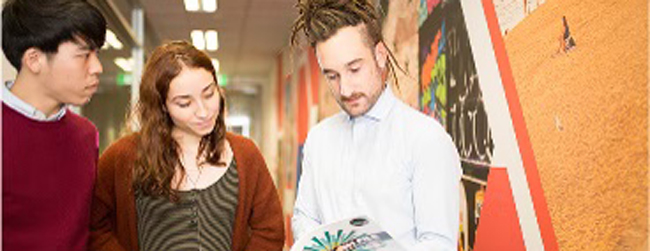 Drei junge Leute schauen gemeinsam in ein Buch beim Cambridge Certificate Vorbereitungskurs in Melbourne