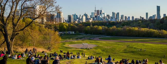 Abendstimmung im Park bei einer Englisch-Sprachreise in Toronto Viele Menschen entspannen in der Abendsonne im Park mit Blick auf die Skyline von Toronto