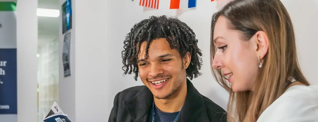 Eine Frau und ein Mann betrachten eine Broschüre im Englisch-Unterricht an der Sprachschule in Toronto