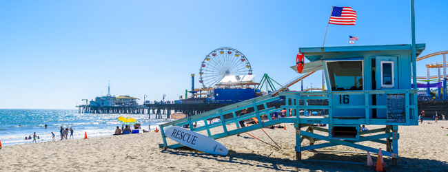 Viele Freizeitmöglichkeiten am Strand von Santa Monica bei einer Sprachreise nach Los Angeles Rettungsturm mit Strand, Meer und Riesenrad im Hintergrund am Strand von Santa Monica