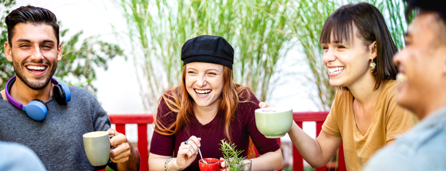 Vier freunde trinken Kaffee bei einer lustigen Unterhaltung bei einer Portugiesisch-Sprachreise in Lissabon