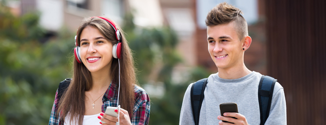 Unterwegs in London bei einer Sprachreise für Schüler Zwei Schüler mit Handy und roten Kopfhörern unterwegs durch London bei einer Schülersprachreise