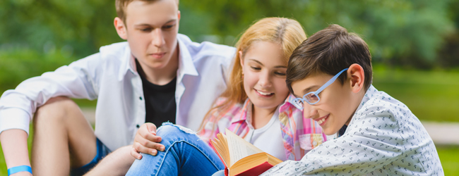 Drei Jugendliche sitzen zusammen auf einer Wiese bei einer LISA! Sprachreise für Schüler in Bedford