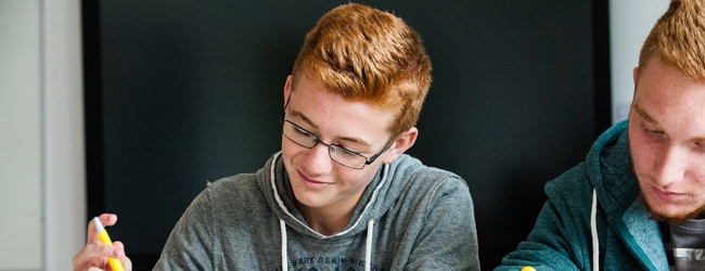 Konzentriertes Arbeiten im Unterricht bei einer Schülersprachreise in Dublin Zwei Jungen arbeiten konzentriet am Schreibtisch bei einer Sprachreise in Dublin für Schüler